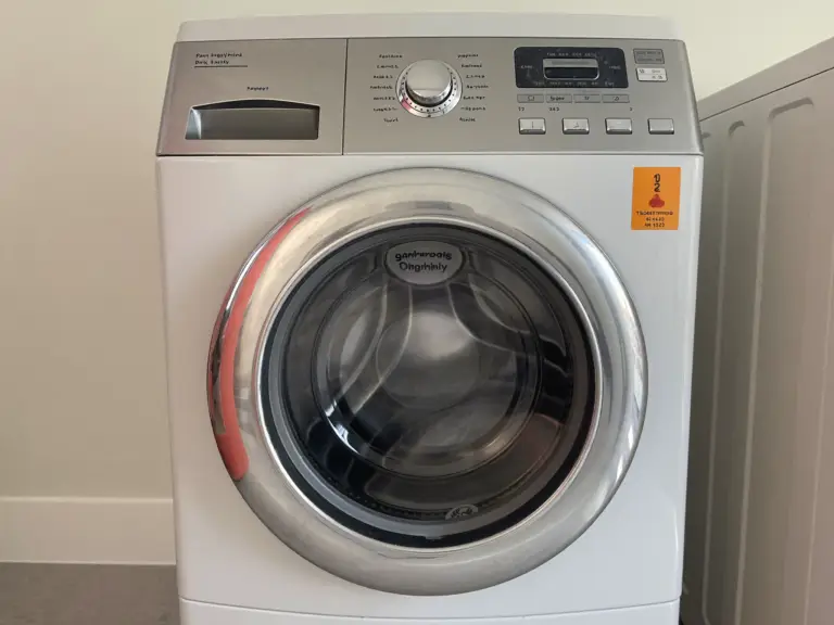 A front-load clothes dryer with the drum door open in a Toronto laundry room